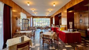 a restaurant with tables and chairs in a room at Sirály in Balatonlelle