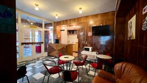 a restaurant with tables and chairs in a room at Sirály in Balatonlelle
