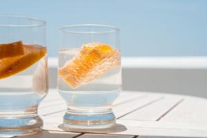 un verre d'eau avec un morceau d'orange dans l'établissement Kastro suite, à Naxos Chora