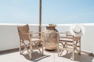 deux chaises et un chapeau assis à côté d'une table dans l'établissement Kastro suite, à Naxos Chora
