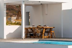 a dining area with a wooden table and chairs at Villa Kaya, Plaka in Naxos Chora