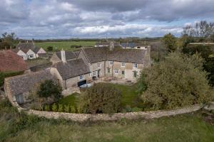 an aerial view of an old house in a field at Brokenborough Farmhouse in Malmesbury