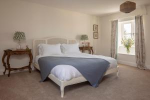 a bedroom with a white bed and a window at Brokenborough Farmhouse in Malmesbury +69 photos