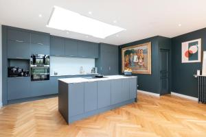a kitchen with blue cabinets and a white counter top at Green Place - Amazing house with swimming pool in Caluire-et-Cuire