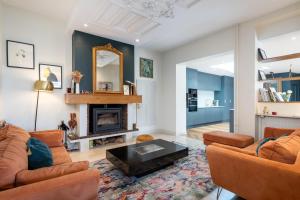 a living room with two couches and a fireplace at Green Place - Amazing house with swimming pool in Caluire-et-Cuire