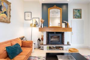 a living room with a couch and a mirror at Green Place - Amazing house with swimming pool in Caluire-et-Cuire