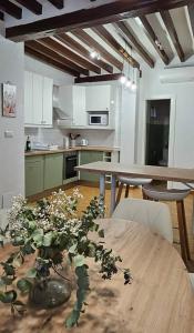 a kitchen with a table with a vase of flowers on it at LovelyLoft Trafalgar in Alicante