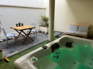 a green bath tub in a room with a table at Appartement bien être à Colmar in Colmar