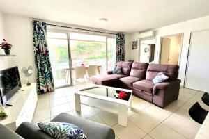 a living room with a couch and a table at Hanitea flat at the entrance of Papeete 1bdr - Wi-Fi - park - 3 pers in Papeete