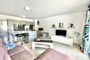 a living room with a couch and a kitchen at Hanitea flat at the entrance of Papeete 1bdr - Wi-Fi - park - 3 pers in Papeete