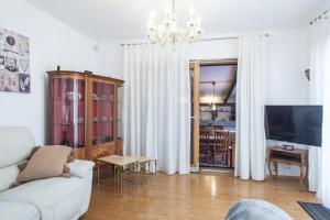 een woonkamer met een witte bank en een televisie bij House with pool in Marcana in Marčana