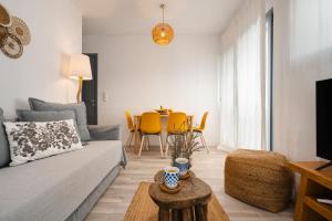 a living room with a couch and a table at Yara Apt 40m from the Beach Jacuzzi & Rooftop in Agia Anna Naxos