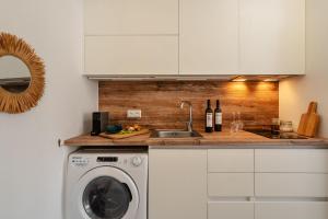 a kitchen with a sink and a washing machine at Yara Apt 40m from the Beach Jacuzzi & Rooftop in Agia Anna Naxos +37 photos