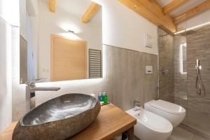ein Badezimmer mit einer großen Badewanne und einer Toilette in der Unterkunft Hotel Faloria in Moena + 46 Fotos