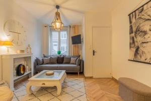 a living room with a couch and a table at Maison 2 chambres avec jardin & parking gratuit in Marcq-en-Baroeul