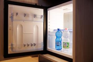 an open refrigerator with two bottles of water in it at Casa San Giuseppe in Rome +77 photos