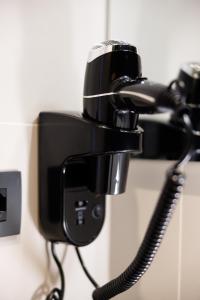 a black phone hanging on a wall at Casa San Giuseppe in Rome