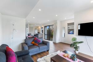 a living room with two couches and a tv at Auckland airport homes six minutes from airport three bedrooms two and half bathrooms in Auckland