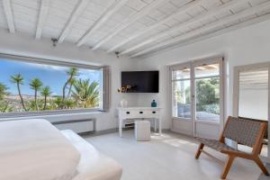 una camera da letto bianca con un letto e una finestra di Alia Villa Mykonos a Mykonos Città