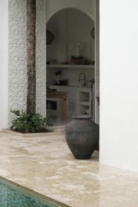 a large vase sitting on the floor of a room at Poem House Bali in Munggu