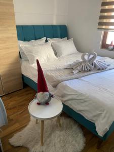 a gnome sitting on a table next to a bed at VILA JAHORINSKI RAJ A5 in Jahorina