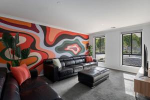 a living room with a couch and a colorful wall at Albury Funk in Thurgoona
