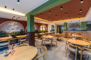 a restaurant with wooden tables and chairs at Echinus Lara Hotel in Antalya