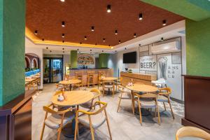 a restaurant with tables and chairs and a kitchen at Echinus Lara Hotel in Antalya