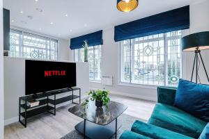 a living room with a couch and a tv at Elysée Suites - Stylish 1 Bed Flat in Southport in Southport +41 photos