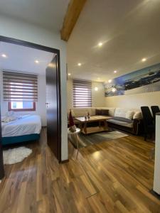 a bedroom with a bed and a couch and a table at VILA JAHORINSKI RAJ A5 in Jahorina