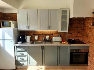 a kitchen with white cabinets and a brick wall at Santos LODGE surf - 5 minutes walking to Praia da Rocha in Portimão
