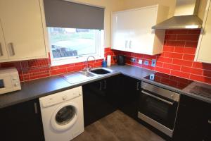 a kitchen with a sink and a washing machine at Pinegrove flat in Fort William +5 photos