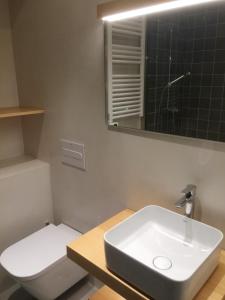 a bathroom with a sink and a toilet and a mirror at Apartamentos Angelito Playa América B in Nigrán