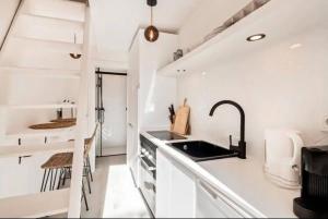 a white kitchen with a sink and a staircase at LovelyLoft Santa Cruz in Alicante +10 photos