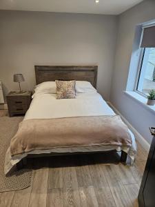 a bedroom with a large bed with a pillow on it at Dalys Place in Béal Átha Póirin