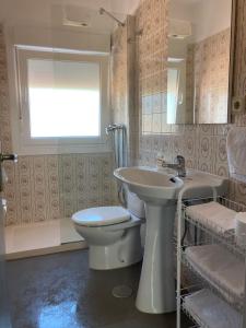 a bathroom with a toilet and a sink and a window at Apartamentos Angelito Playa América Ático in Nigrán