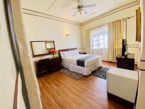a hotel room with a bed and a television at Haylo Hotel in Kampala
