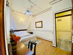 a bedroom with a bed and a table and a door at Haylo Hotel in Kampala