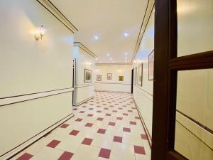 a hallway with a checkered floor and a door at Haylo Hotel in Kampala