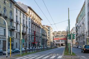 een lege straat met gebouwen en auto's op de weg bij Hotel Demo' in Milaan