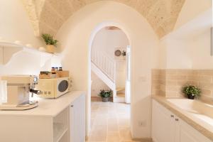 eine Küche mit einer Spüle und einer Mikrowelle auf der Theke in der Unterkunft Le Antiche Volte in Fasano