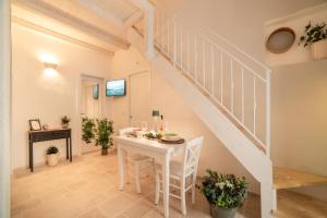 einen weißen Tisch und Stühle in einem Zimmer mit einer Treppe in der Unterkunft Le Antiche Volte in Fasano