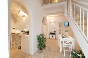 eine Küche und ein Wohnzimmer mit Treppe und Tisch in der Unterkunft Le Antiche Volte in Fasano