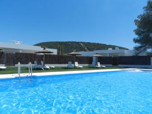 a swimming pool with chairs and umbrellas at DADA CAÑOS in Los Caños de Meca