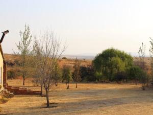 a view of a field with trees and a house at Mosamane Guest Farm in Rosendal +4 photos