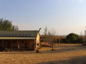 a house with solar panels on it in a field at Mosamane Guest Farm in Rosendal