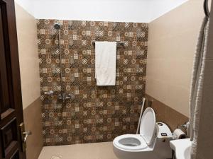 Un pequeño baño con inodoro y ducha. en Solace Inn, en Islamabad