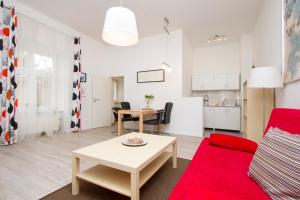 ein Wohnzimmer mit einem roten Sofa und einem Tisch in der Unterkunft Apartment Uthman Berlin-Neukölln in Berlin
