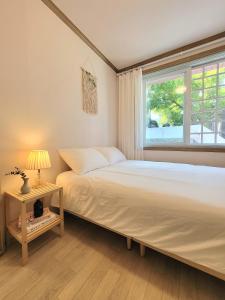 a bedroom with a large bed and a window at PATIO Stay in Daegu