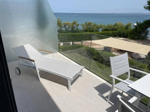 a white bench and a chair on a balcony with the ocean at Apartments Marvi Ugljan in Ugljan +22 photos